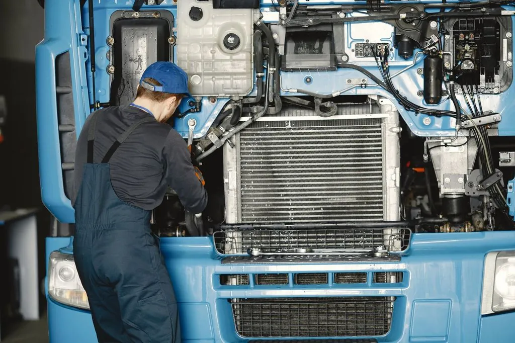 Mecánico revisando el motor de un vehículo pesado en un taller